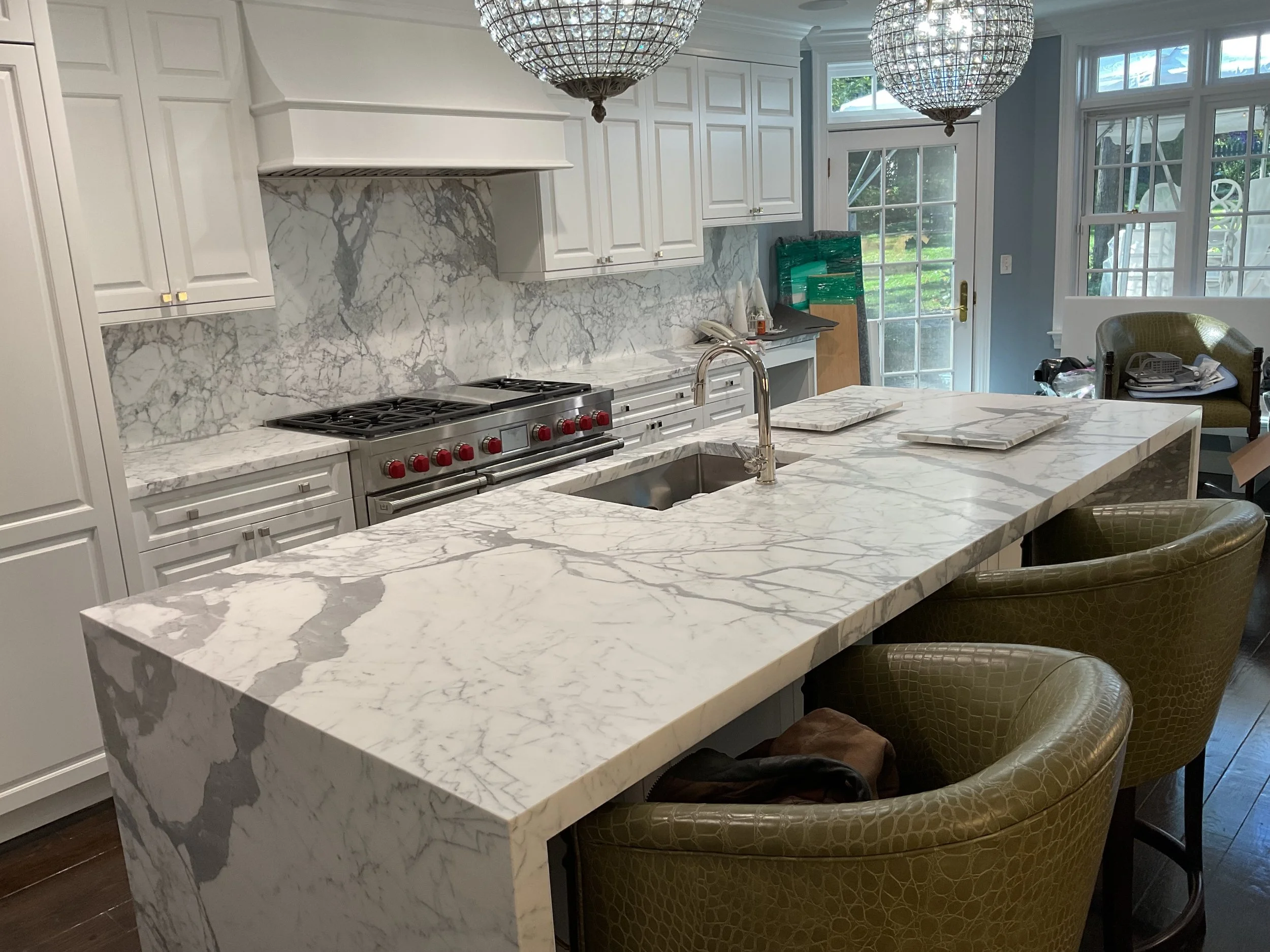 Statuario bookmatched marble waterfall kitchen island and backsplash by Intermarble in Port Washington, New York