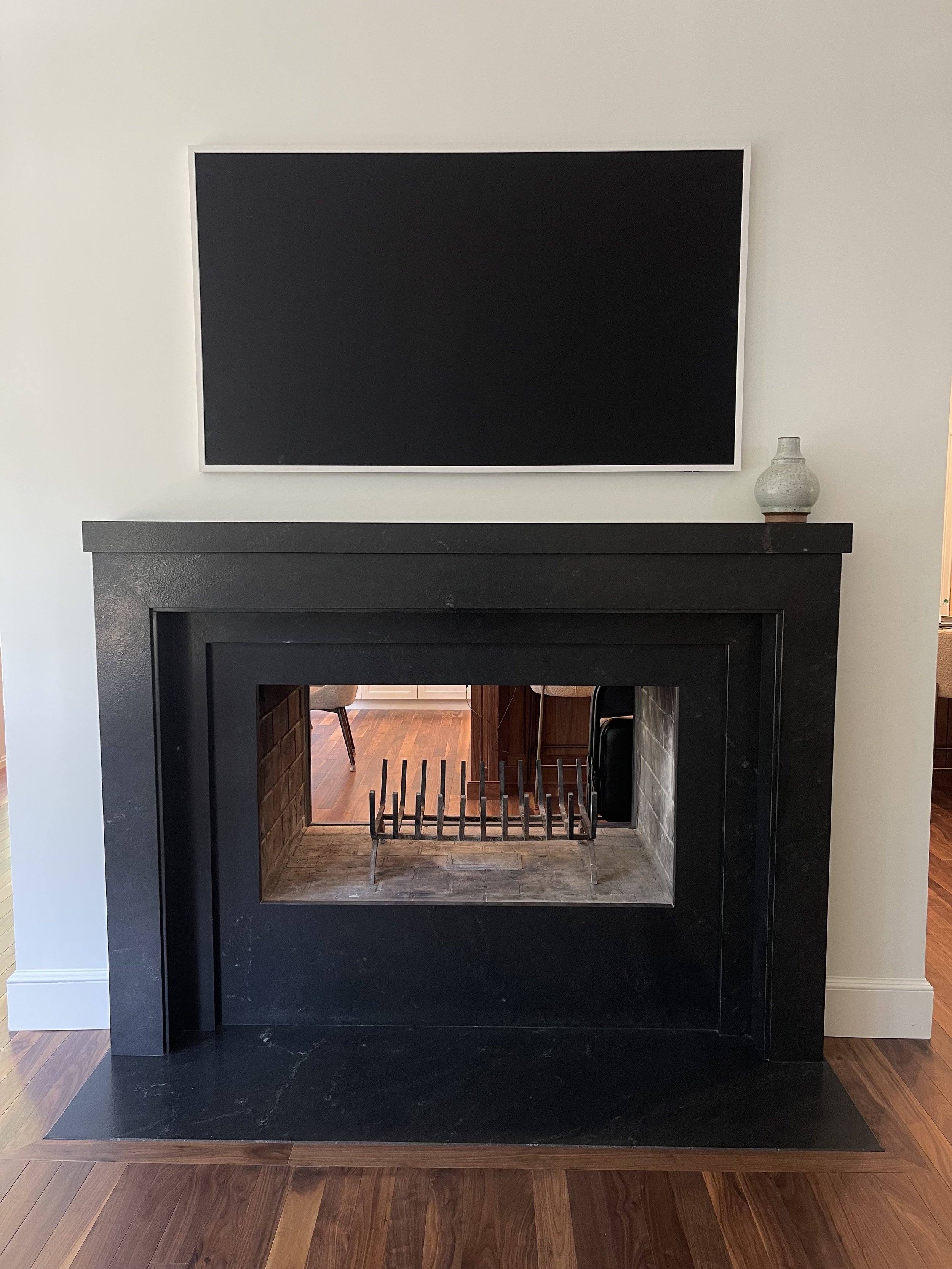 Mitered fireplace surround, mantle, and hearth in honed black absolute granite by Intermarble in Nassau County, NY