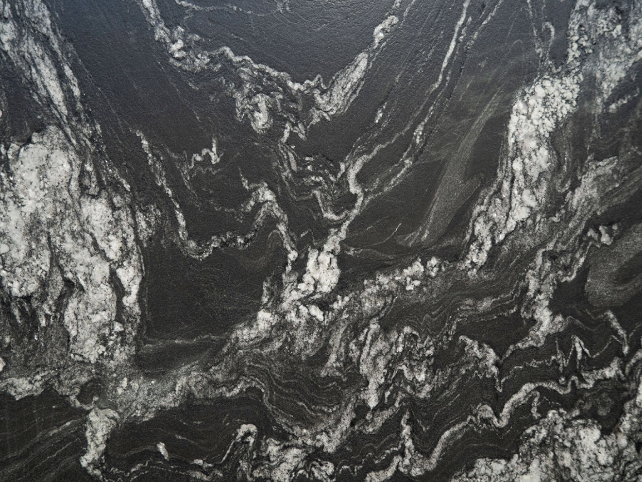 Natural granite stone featuring a dark base with contrasting white mineral veining, known for its strength and durability.
