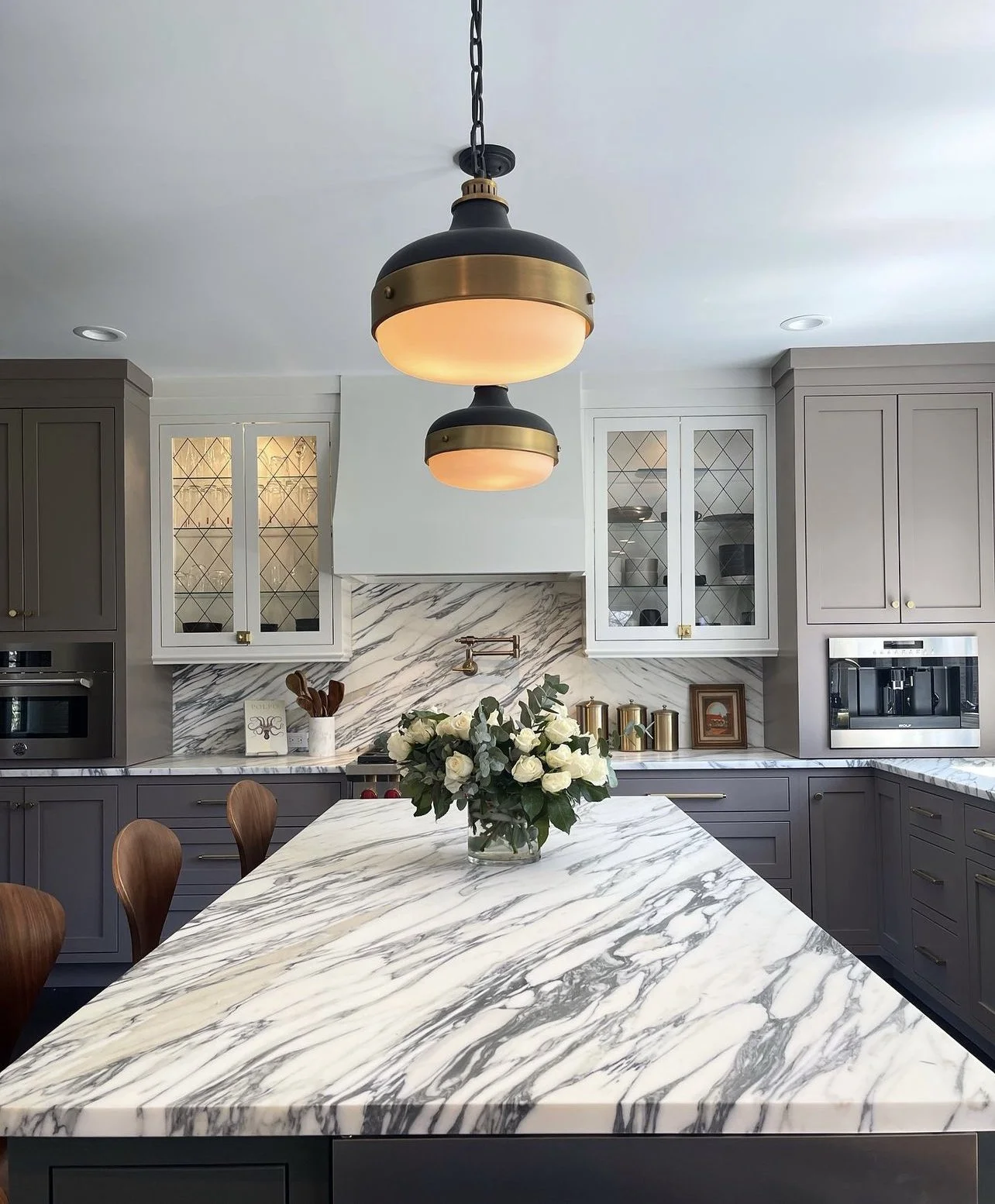 Residential kitchen featuring a custom marble island and matching marble backsplash, highlighting detailed stone fabrication and installation.