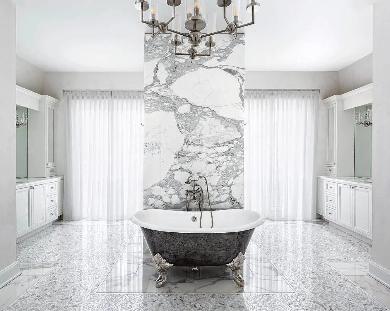 Calacatta marble accent wall behind a luxurious charcoal bathtub with silver legs. Kings Point, Great Neck, New York. 