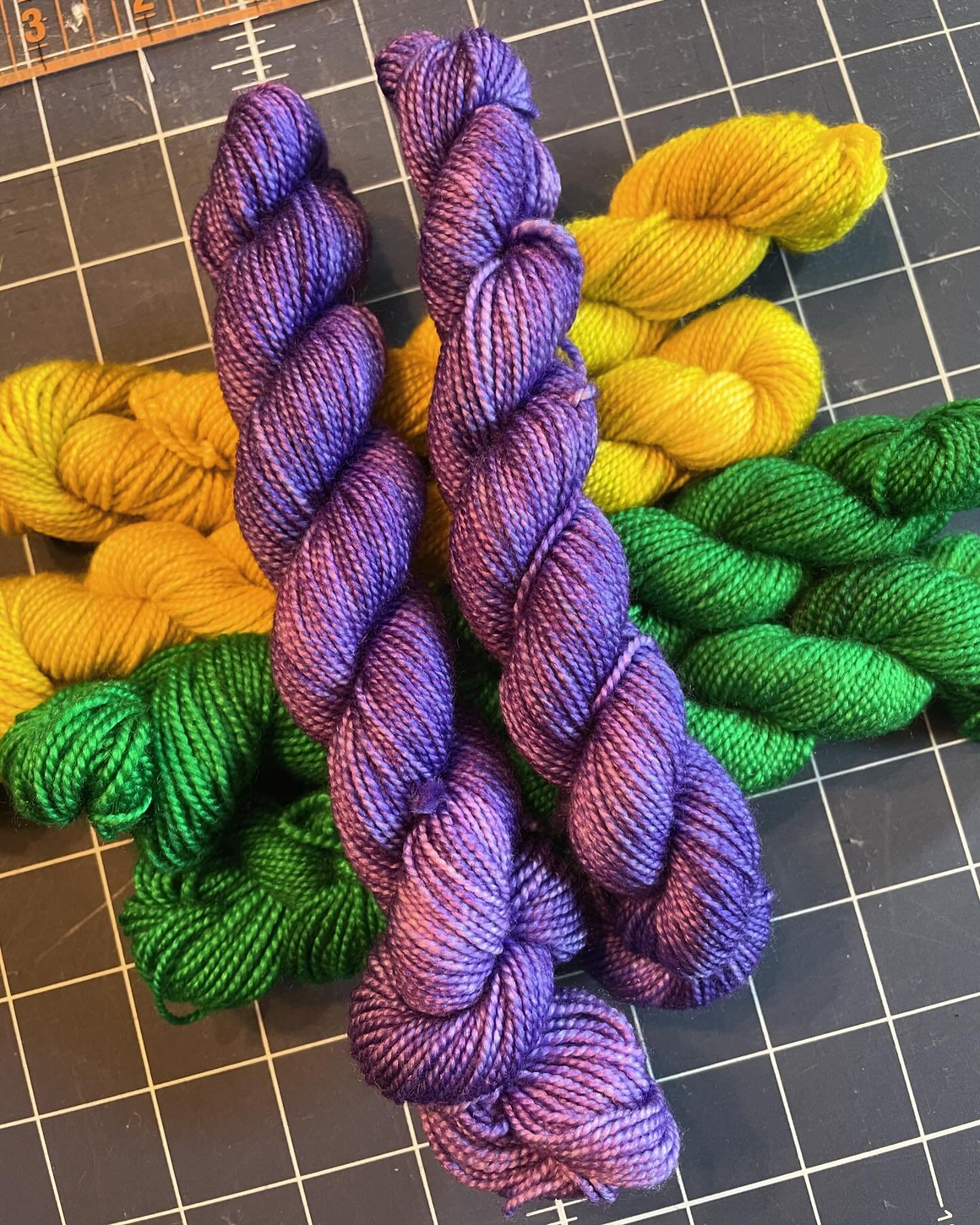 I&rsquo;ve decided I need a pair of Mardi Gras socks in my life. What&rsquo;s everyone&rsquo;s favorite pattern for shorties?  Pictured: Tanzanite, Citrine and Emerald on Shimmer minis. Happy Friday!  #mardigras #socks #yarn #emerald #tanzanite #citr