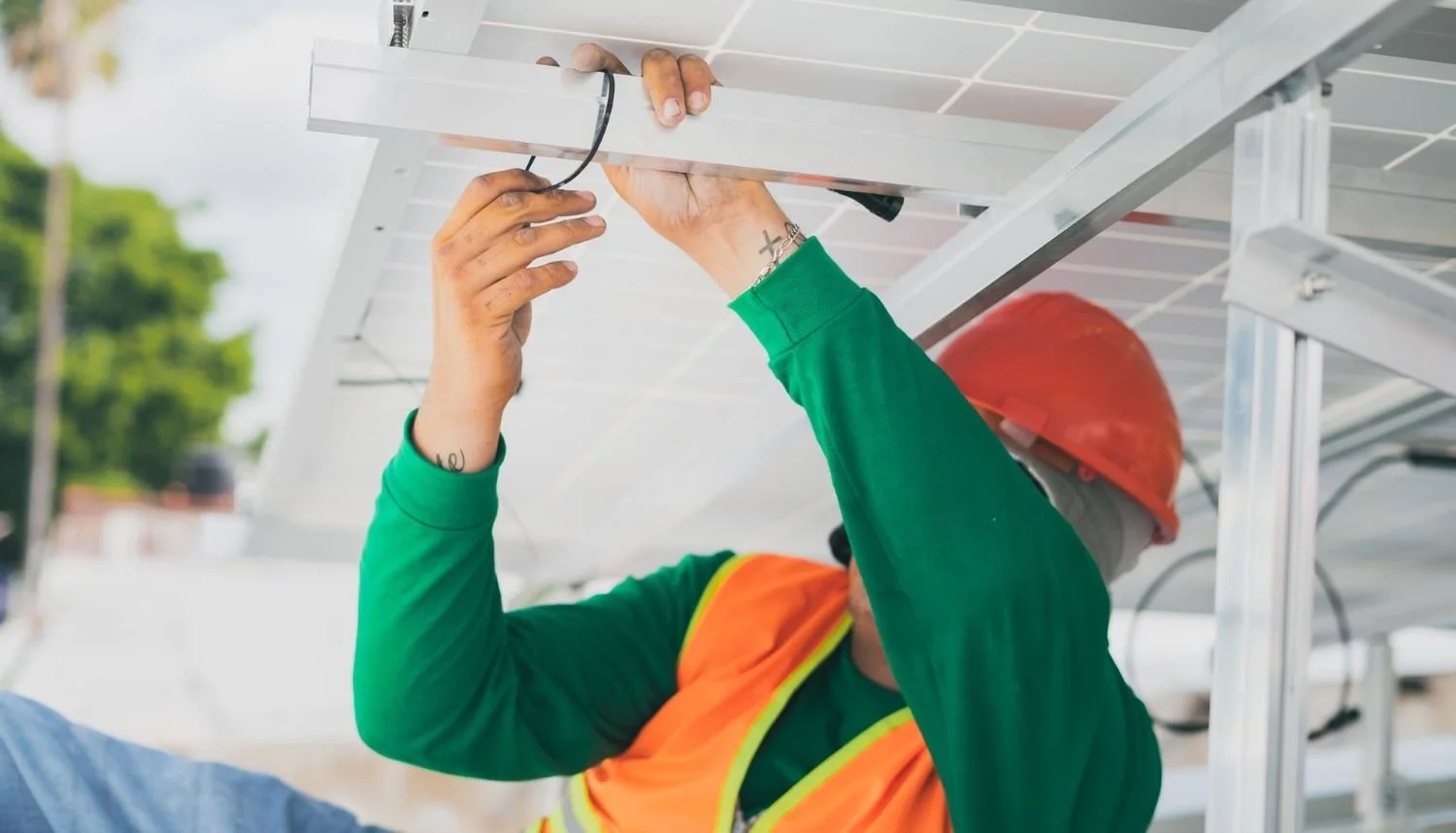 Installateur befestigt Solaranlage von unten
