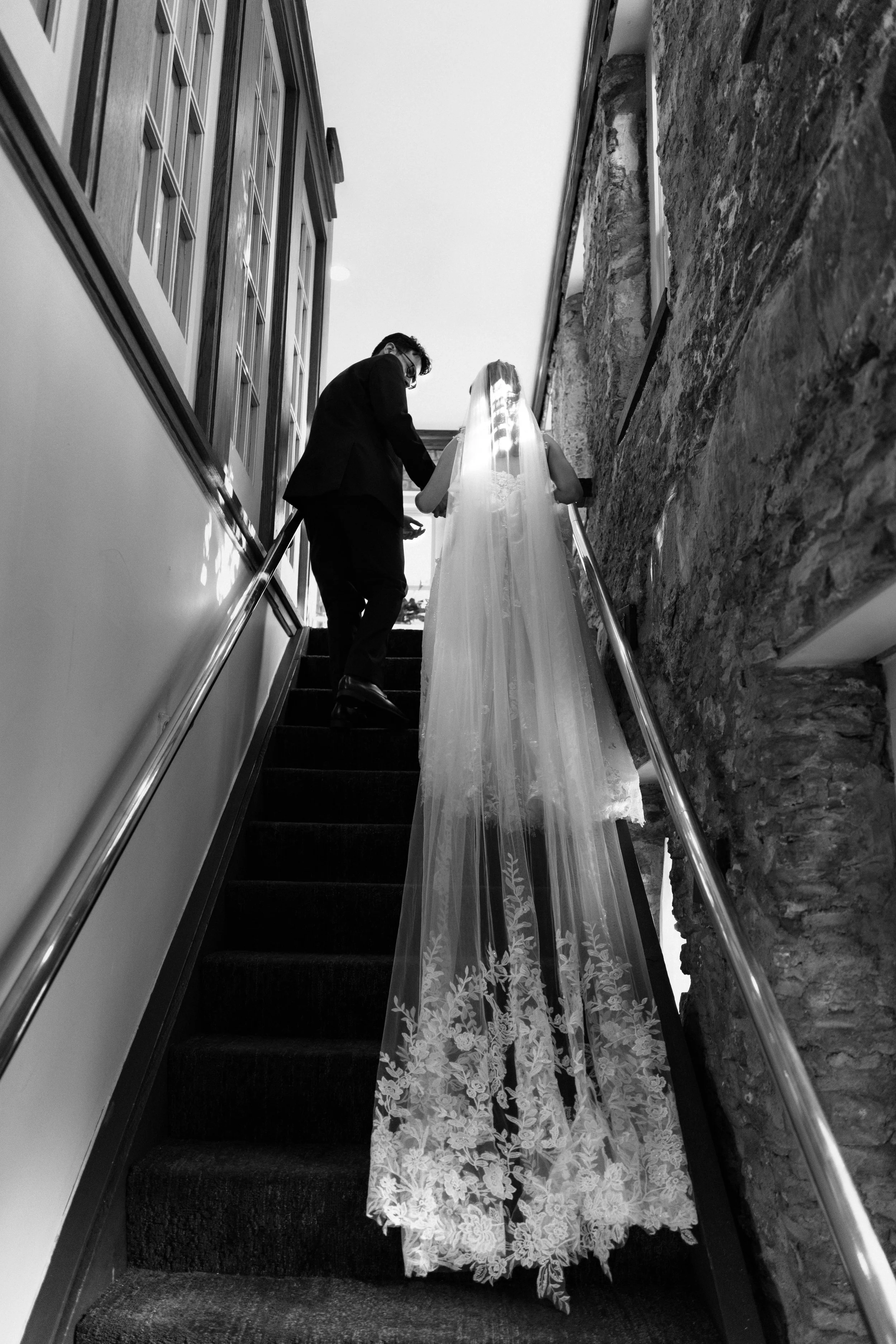 A bride and groom walking up stairs