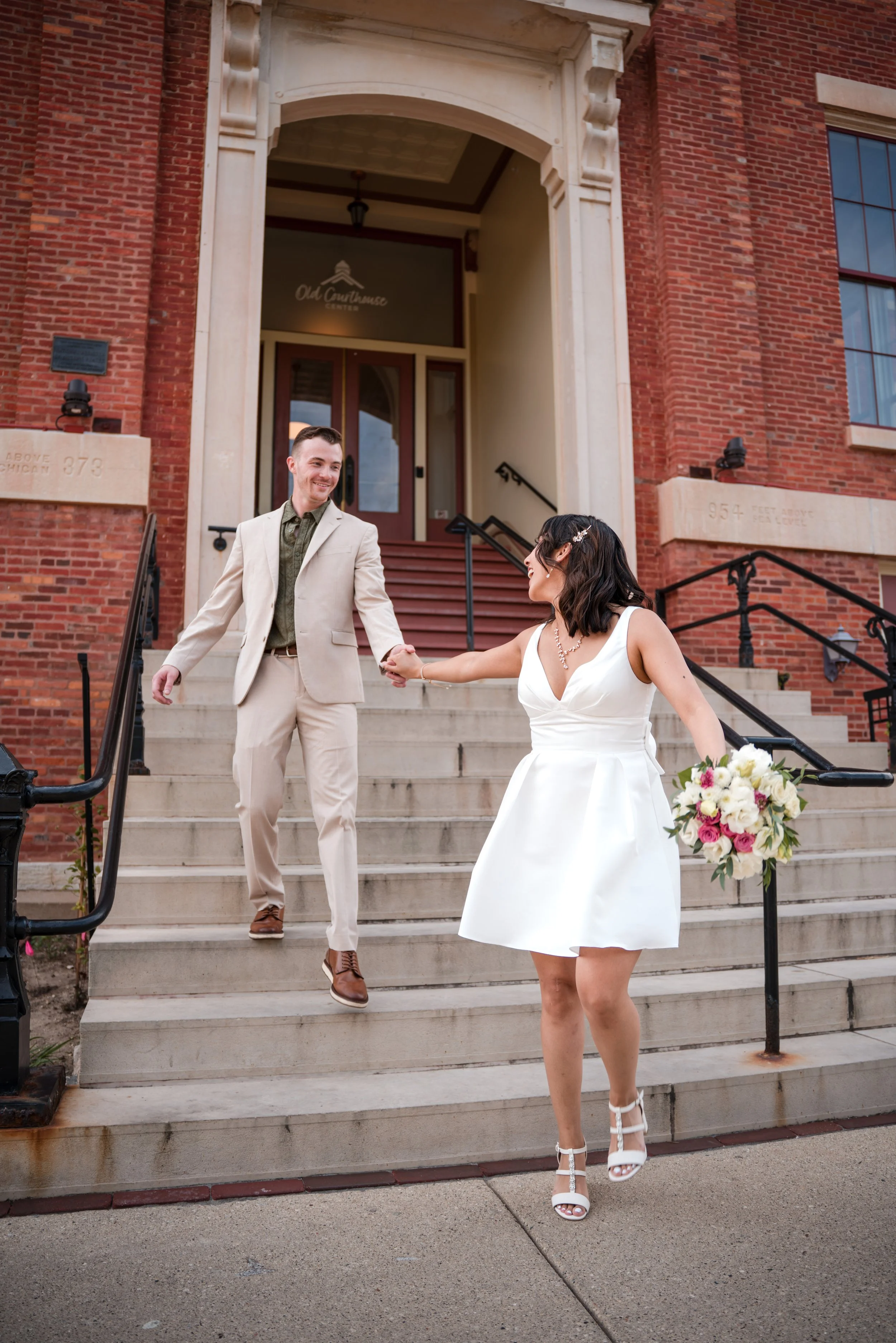 A couple holding hands walking down the stairs