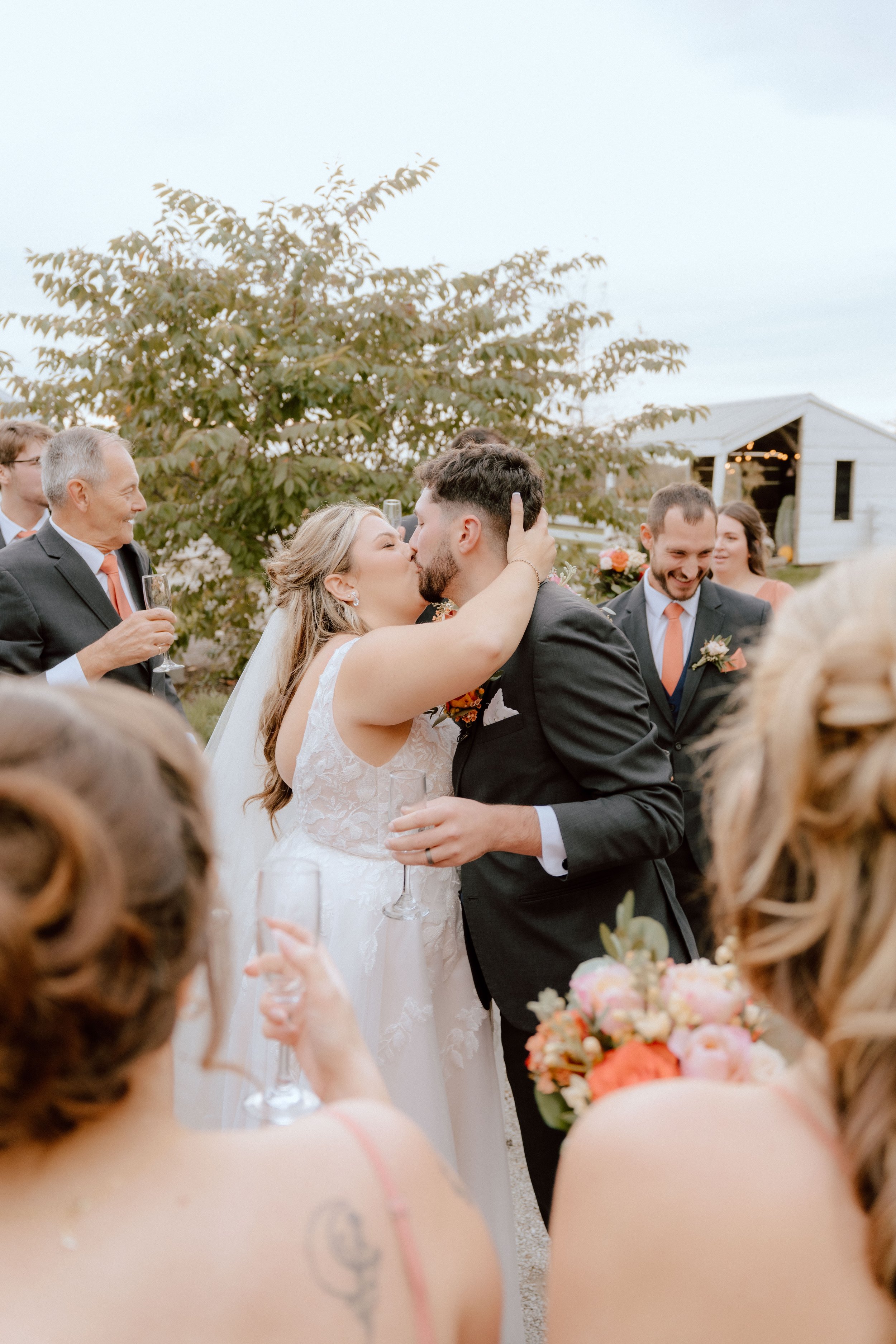 A couple kissing surrounded by friends