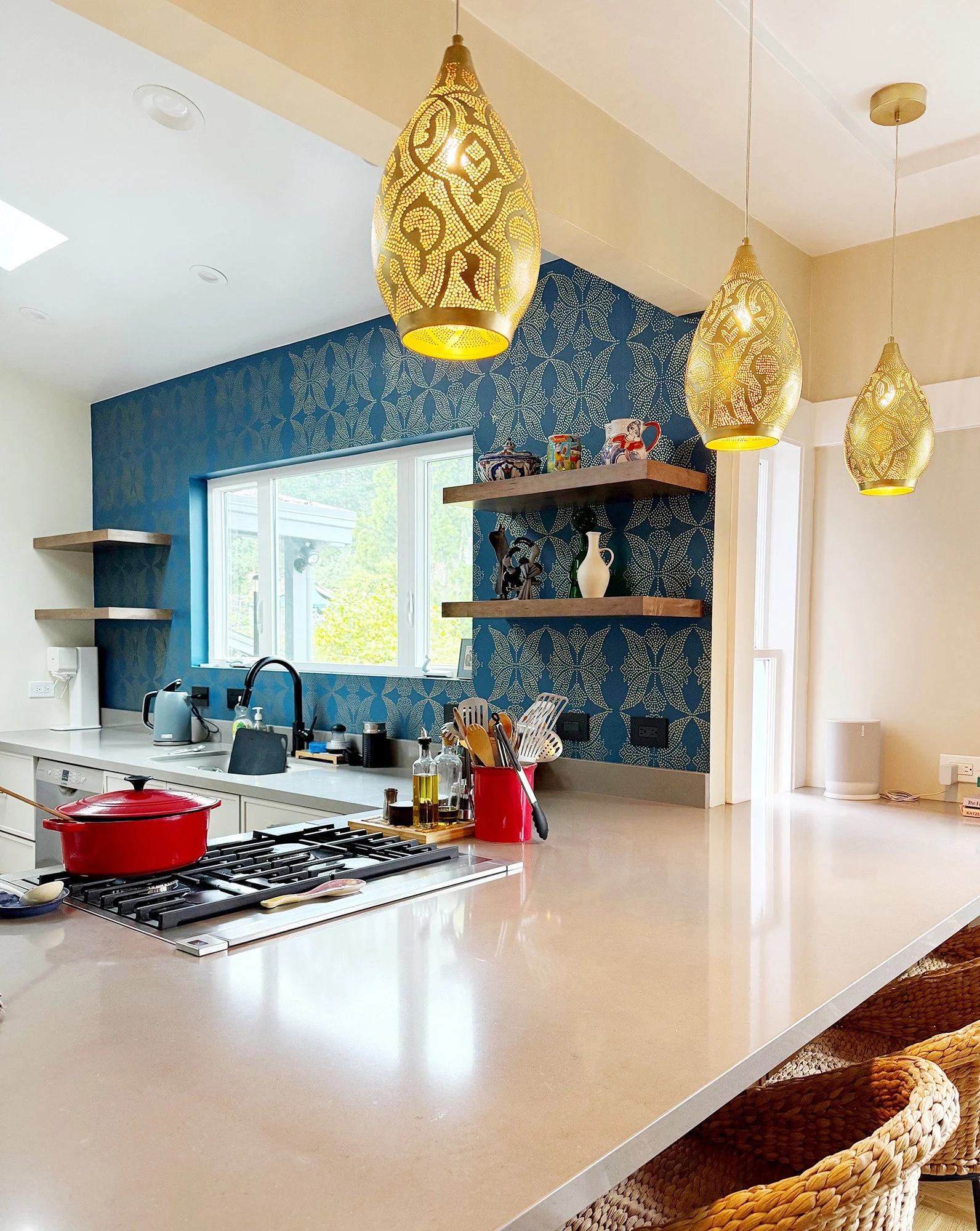 Kitchen with pendant lighting and patterned wall behind cooktop