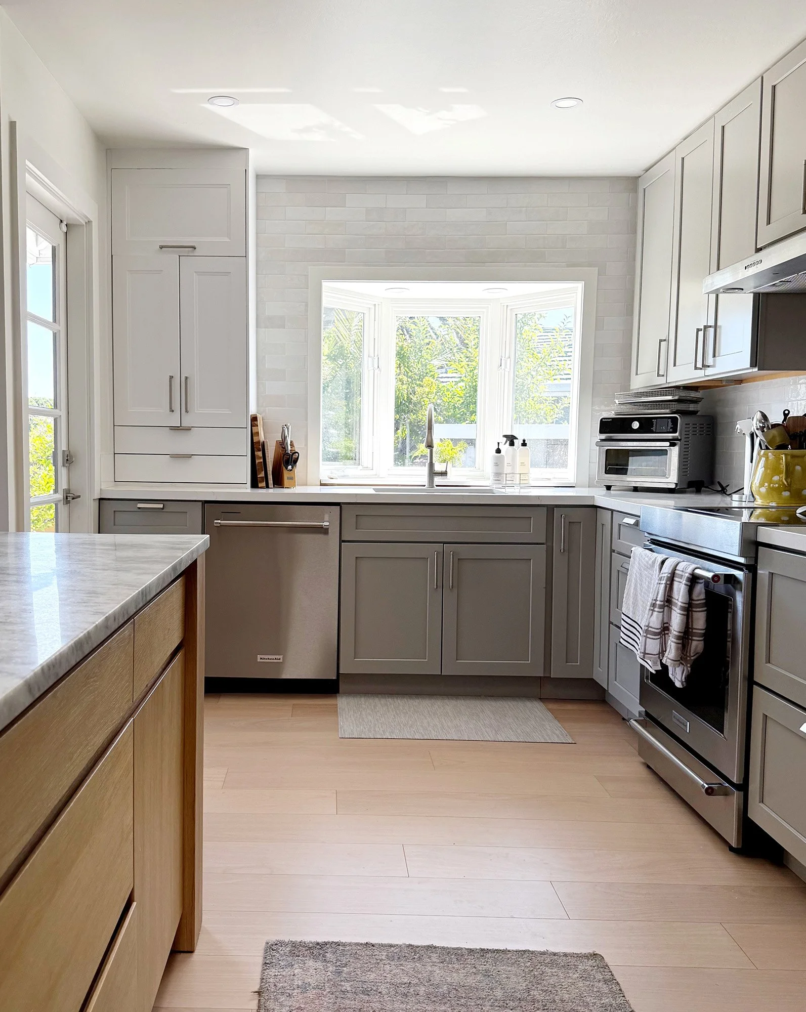 Kitchen with gray cabinets and sink window in Corte Madera home
