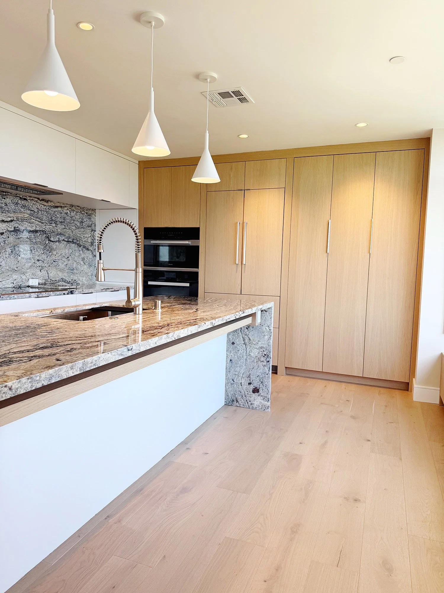 White oak kitchen with quartzite island and integrated appliances