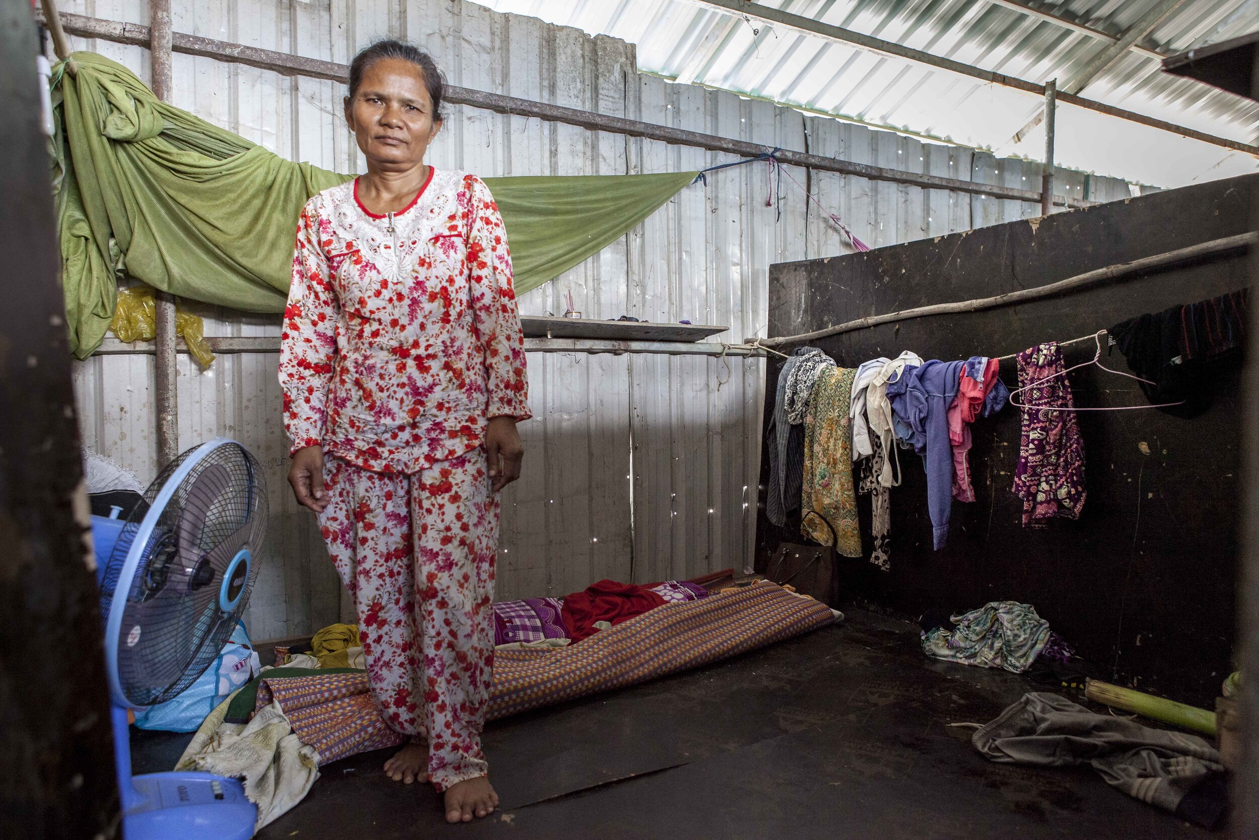  Em Seng, 53 years old and from Prey Veng province, stands in her home on the grounds of the 'Phnom Penh City Centre' construction site. 