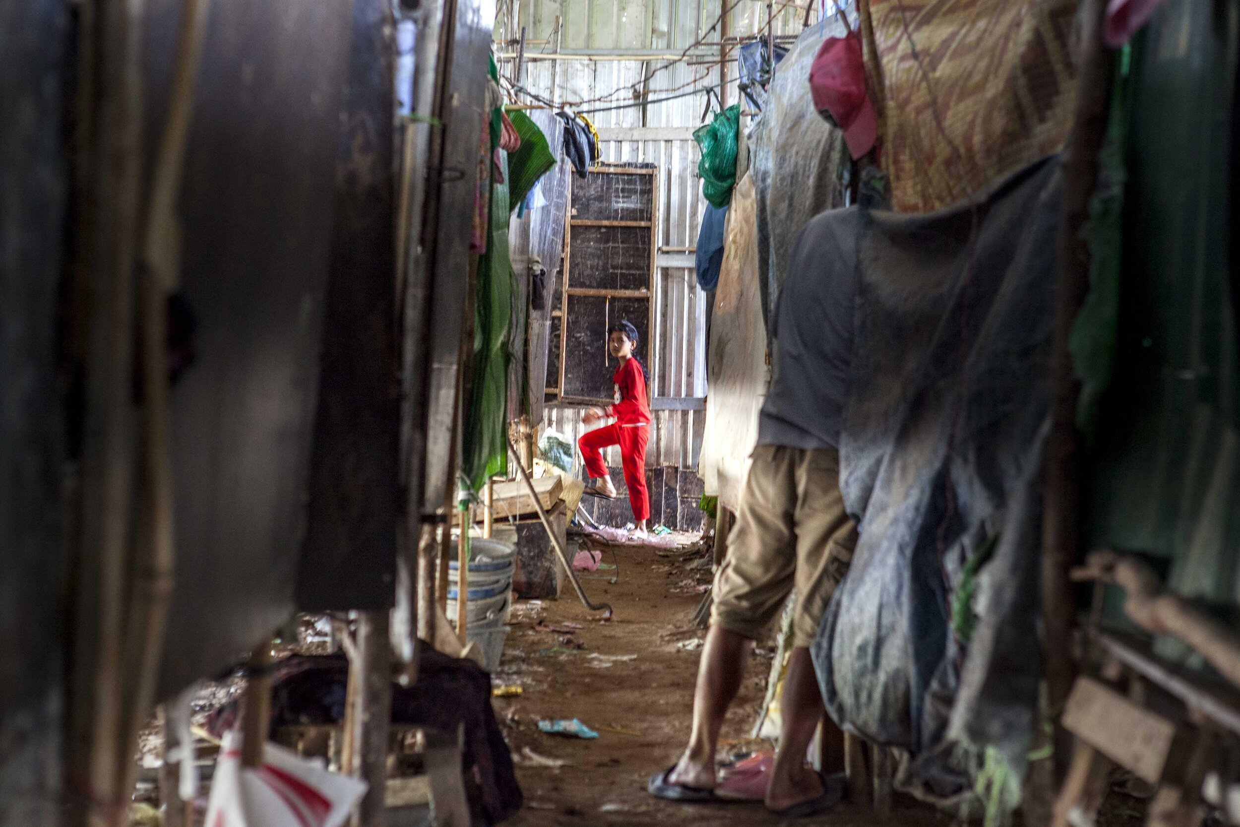  Inside the single, narrow alley in a shed built by the construction company to house its workers on the build site of the 'Phnom Penh City Centre' development. Where employers do provide accommodation for their workers, provisions are rudimentary at