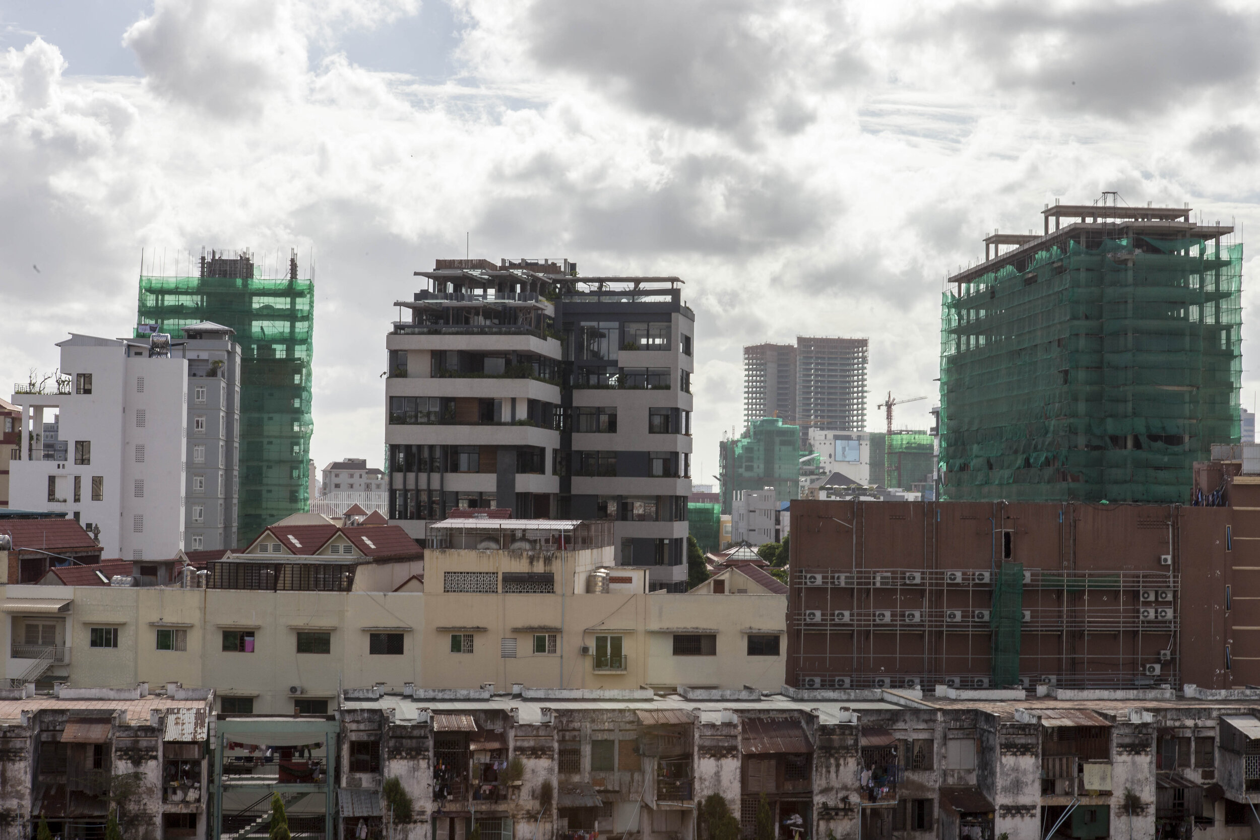  High-rise development and finished buildings dominate the skyline behind Phnom Penh's oldest public housing complex, the low-lying 'White Building'. 