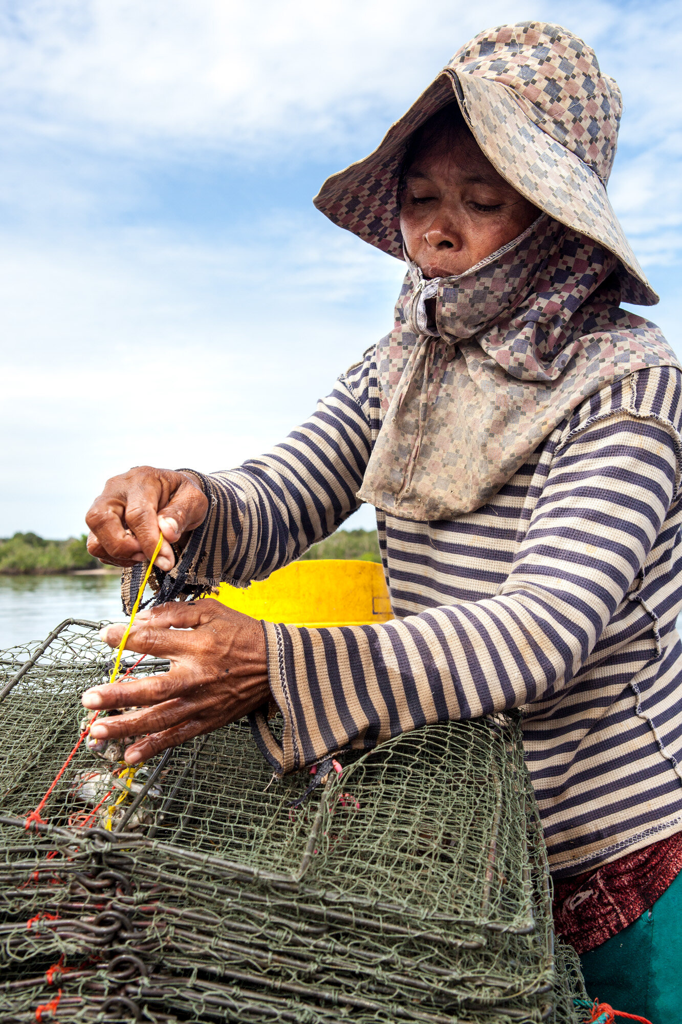  Baiting crab traps, 54 year old widow Hie Nary says her catch is a bare fraction of what it used to be. She and her husband had gone into debt to buy the boat and equipment, and now she is considering relocating to work as a garment worker.  