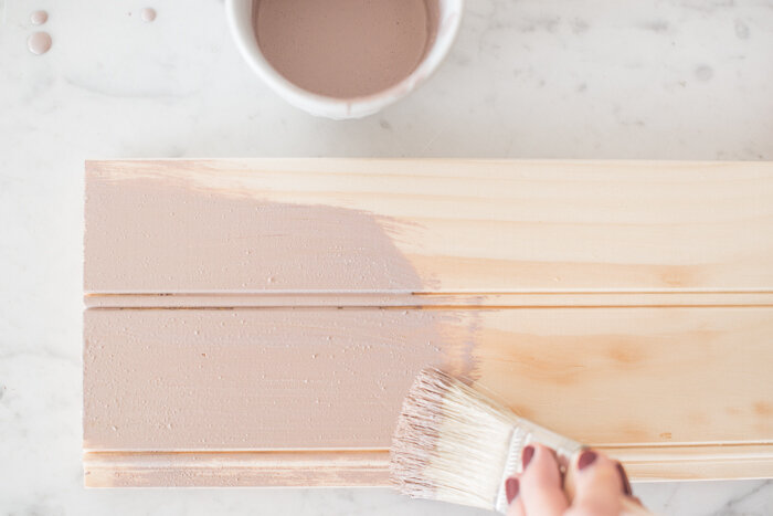 Arabesque Milk Paint by Miss Mustard Seed being brushed onto a raw wood board