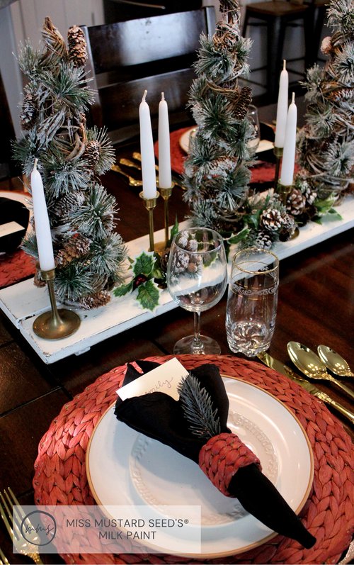 Brass candlesticks with pine tree centerpiece