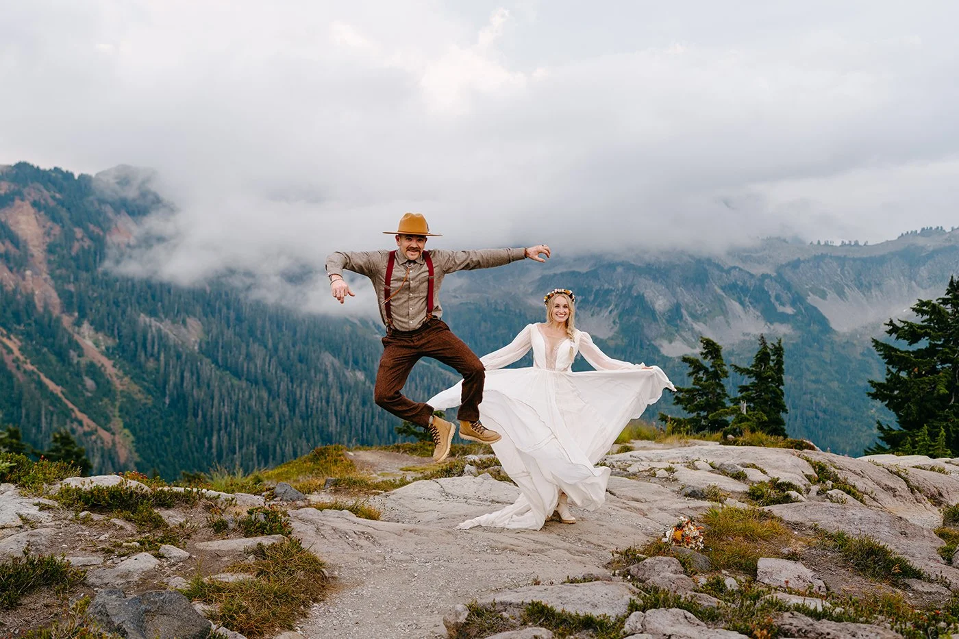 couple jumping in air at artist point wedding