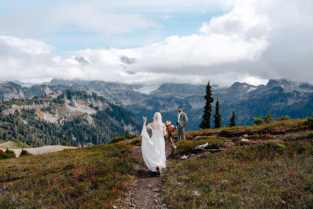 bride hiking to groom with mount shuksan in the background