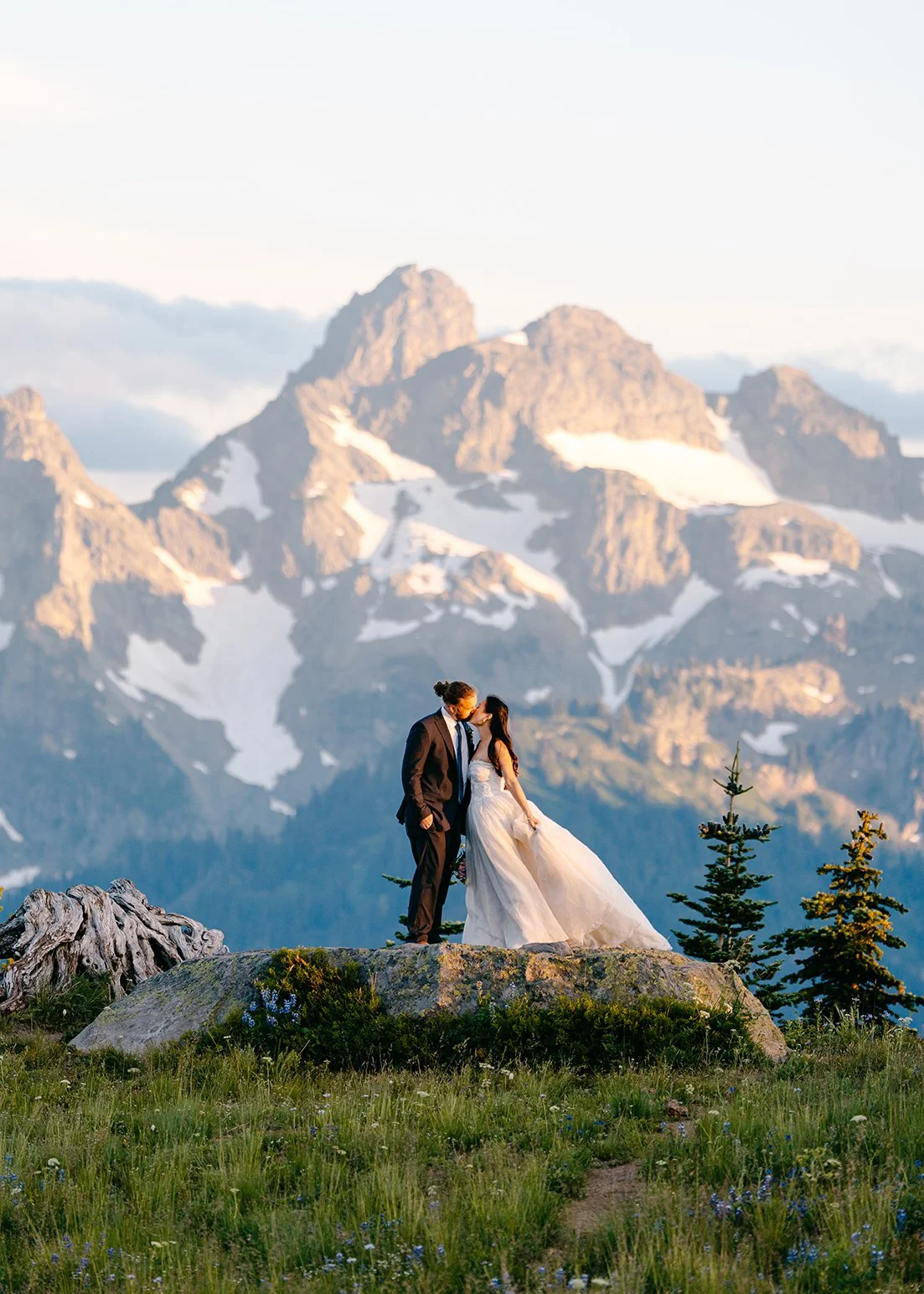 couple kissing in front of mountain range in mount rainier national park