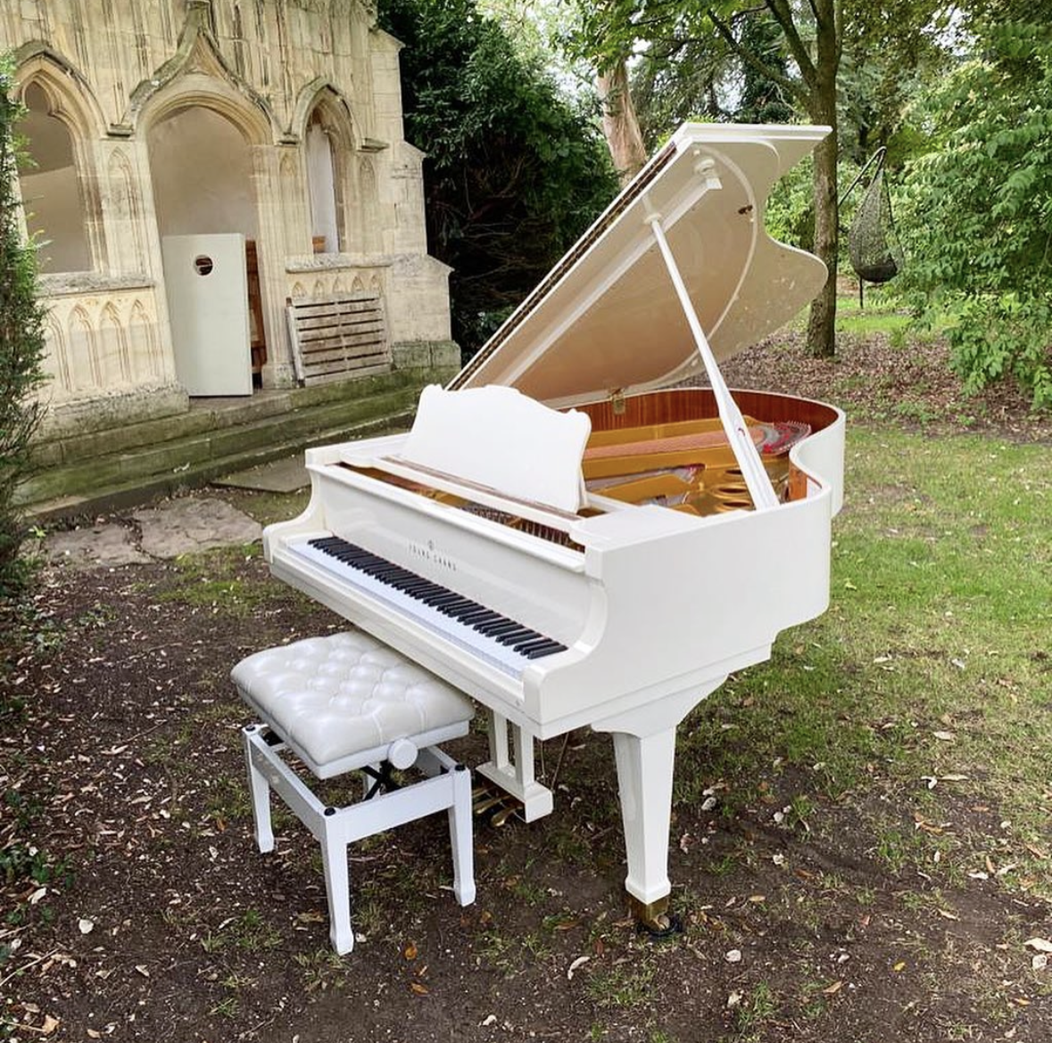white grand piano set up outside