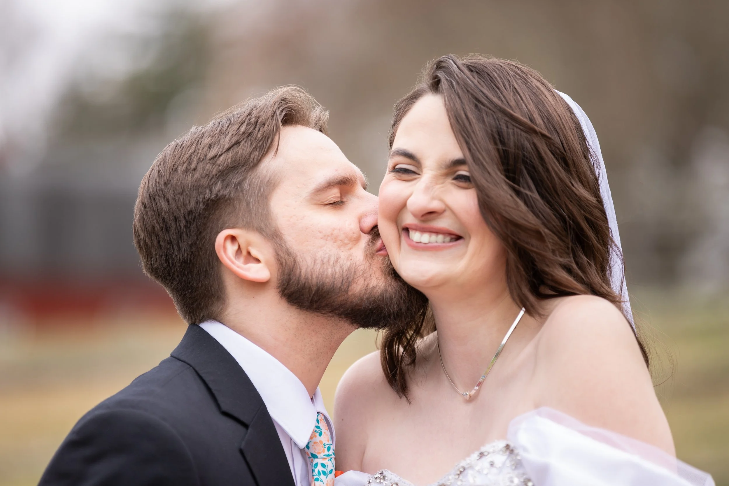 Groom softly kissing bride on the cheek at the Publick House in Sturbridge, Massachusetts.