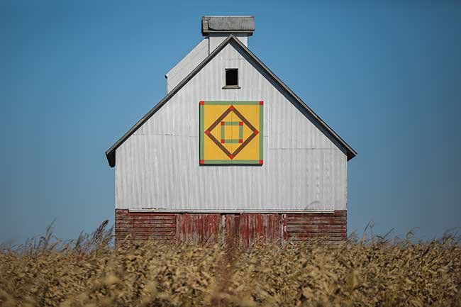 White bardn with green, yellow, and red artwork on the side. Photo by Jamie Harmon.