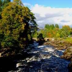 Visit Falls of Dochart Waterfalls as you travel on a group, day tour with Tour Operator, Scotland's Wild. Traveling to Loch Lomond and the Trossachs National Park in the Highlands of Scotland