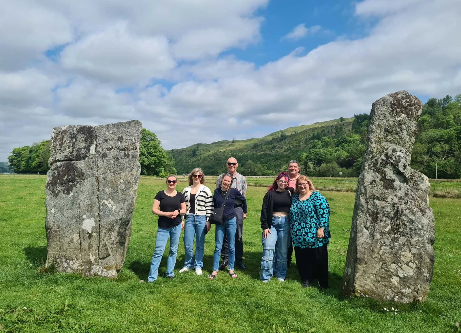 Travellers standing among ancient stones in Kilmartin Glen