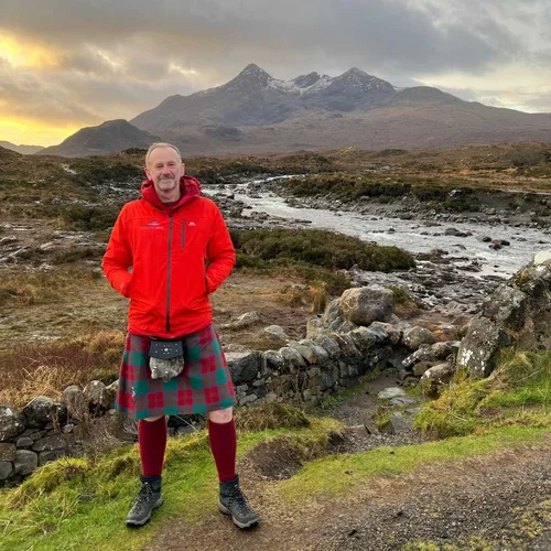 Guide in a kilt beside a river on the Isle of Skye