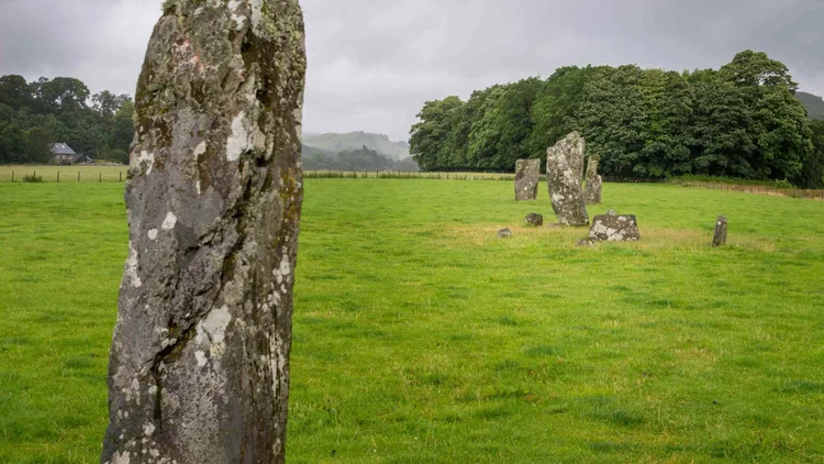 Ancient standing stones in a green field in Kilmartin Glen, on the standing stones and castles day tour from Glasgow