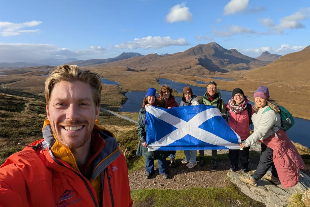 Scotland's Wild guide Derek with guests and a Scotland flag