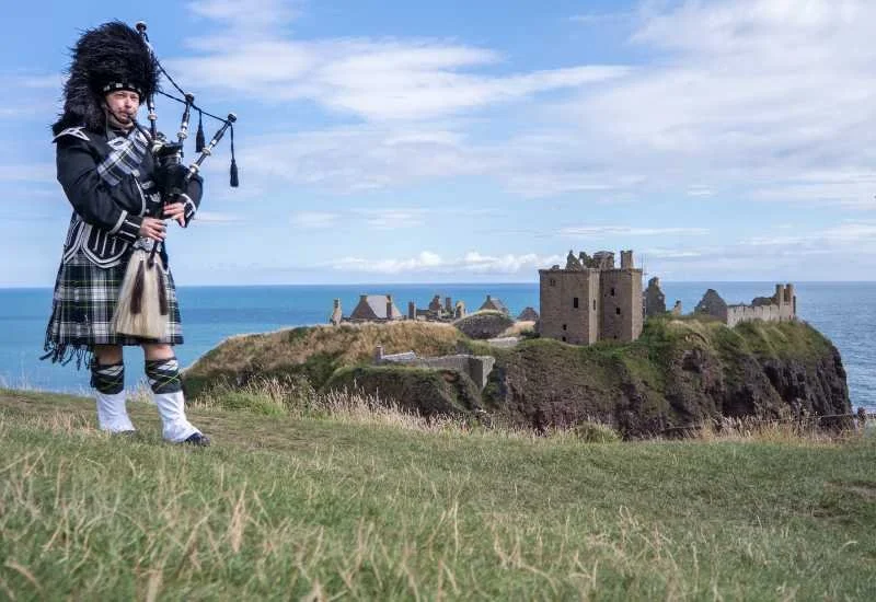 A bagpiper beside Dunnottar Castle on Scotland's east coast