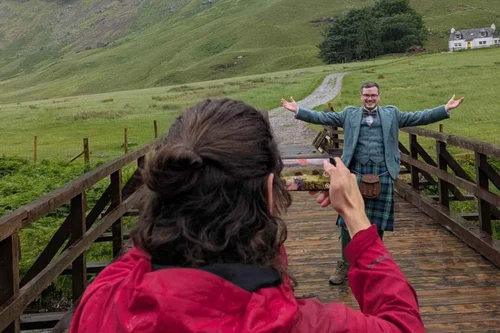 A guide in a kilt on a bridge in Glencoe