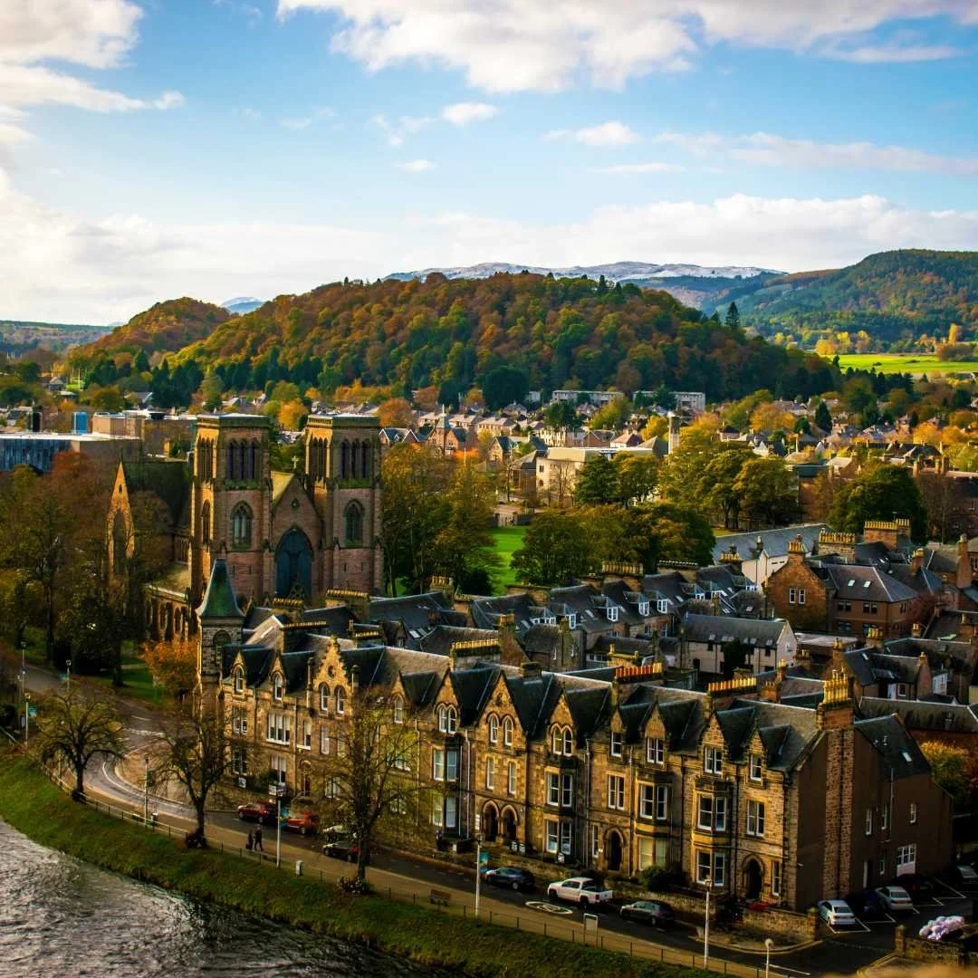 View across the rooftops of Inverness towards wooded Highland hills