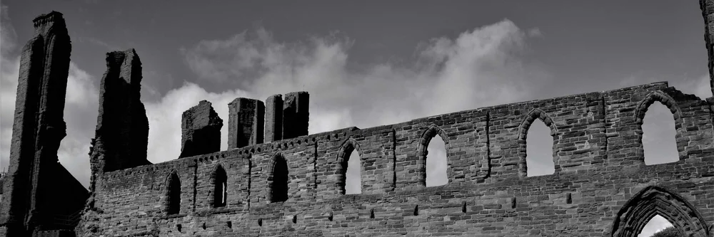 The ruined arches of Arbroath Abbey in black and white