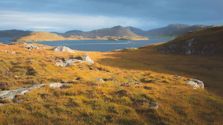 Golden moorland and hills above a sea loch in the Outer Hebrides