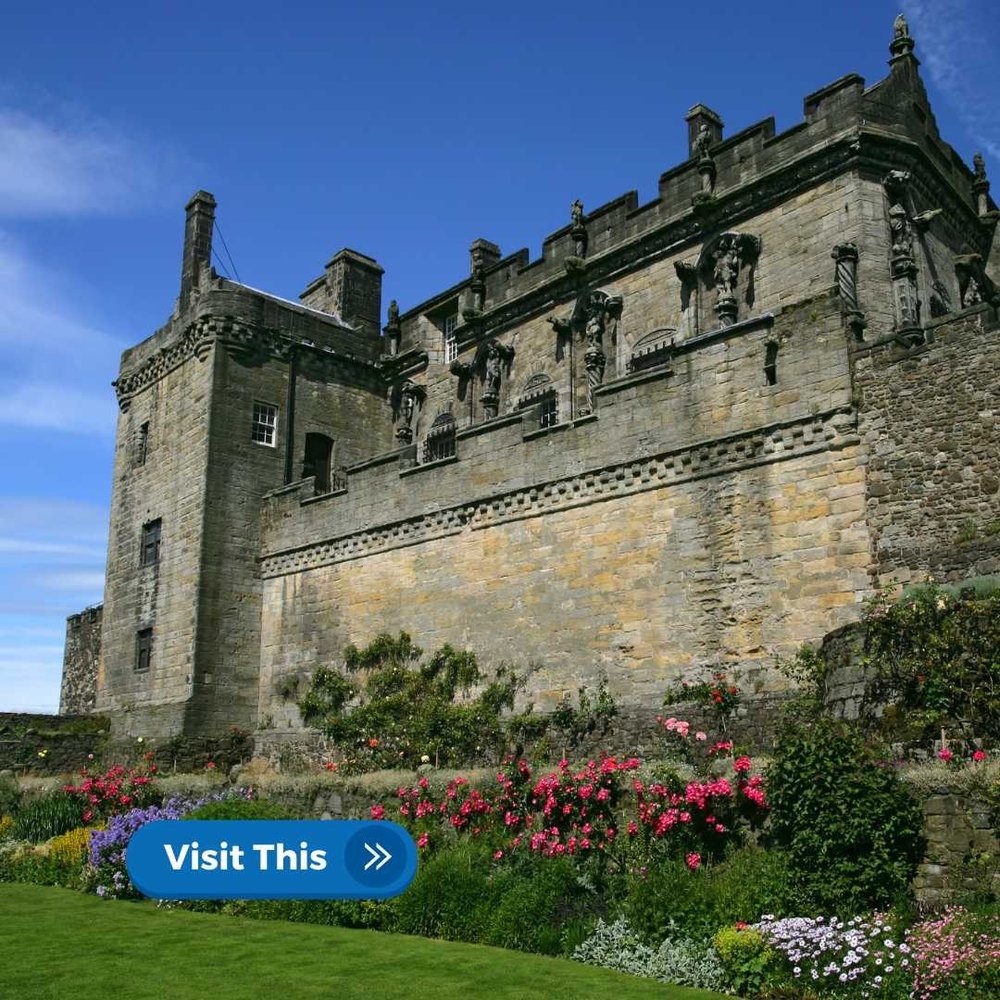 Stirling Castle with its battlements and statues, under a partly cloudy sky