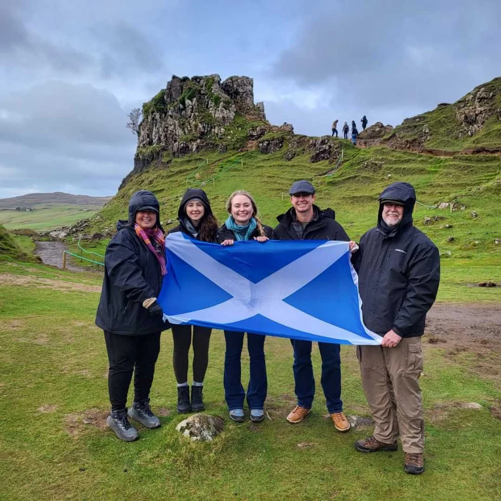 Visitors holding a Scottish flag while exploring Scotland
