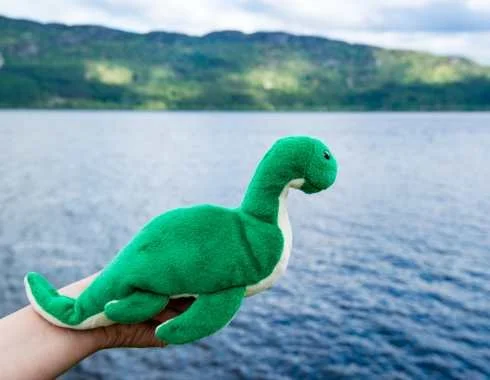 Nessie toy beside Loch Ness