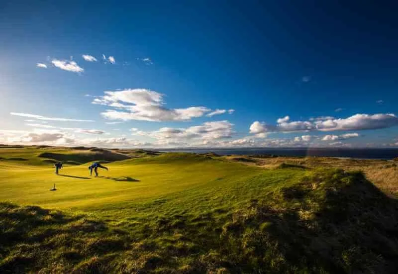 Golfers playing beside the Scottish coast
