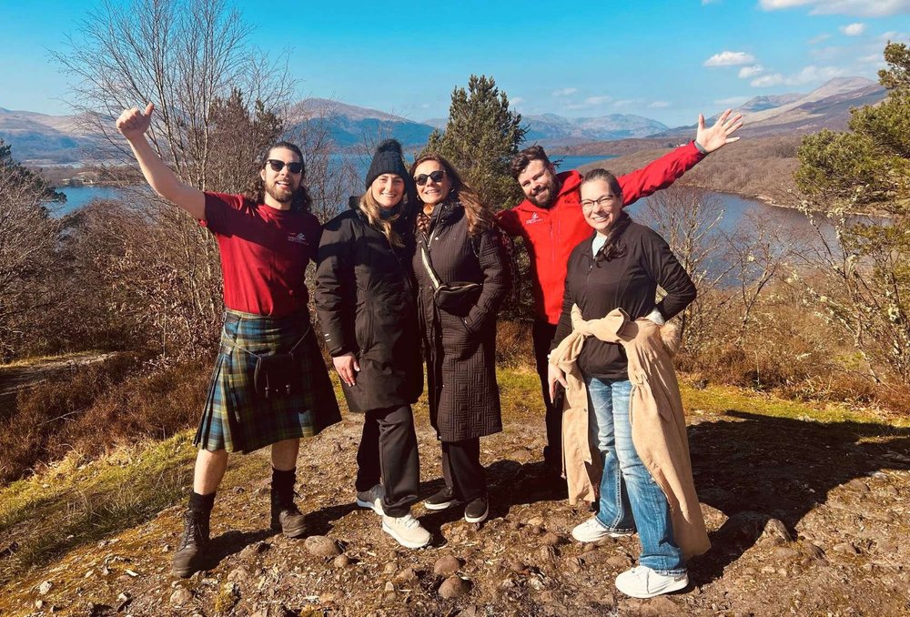 Five Scotland’s Wild team members outdoors with a loch and mountains behind them