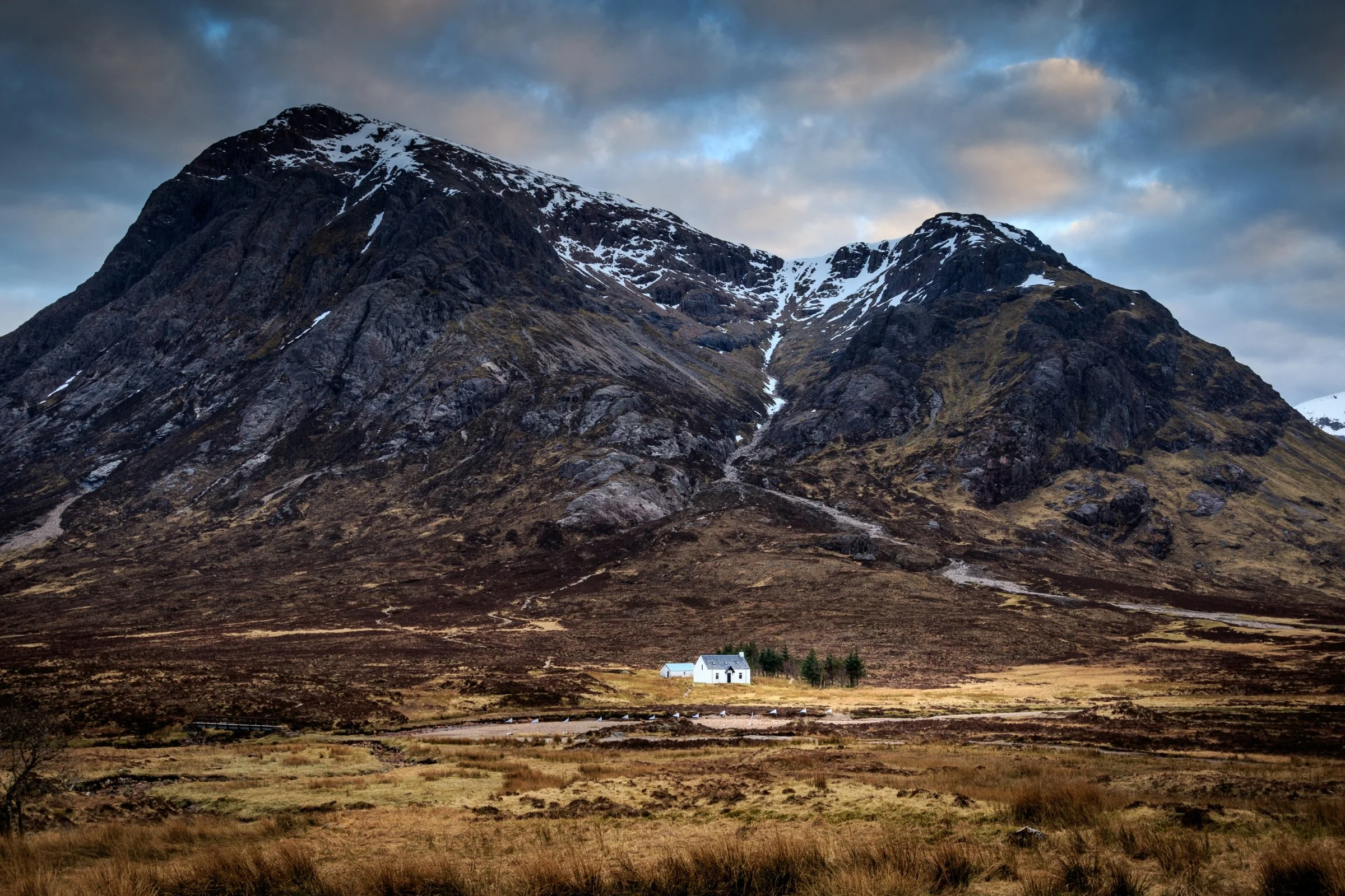 The small white house beneath the steep mountains of Glencoe