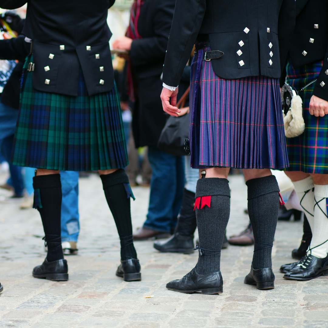 People wearing colourful tartan kilts at a Scottish gathering