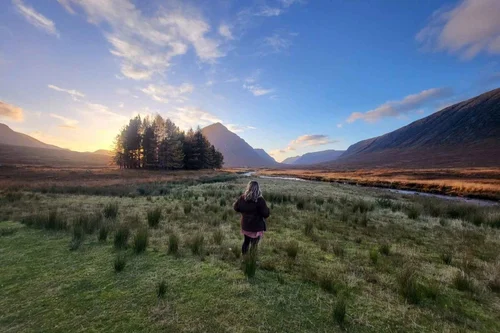 A traveller looking out over a wide Glencoe view
