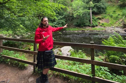 Scotland’s Wild guide Pete explaining nature beside a woodland stream