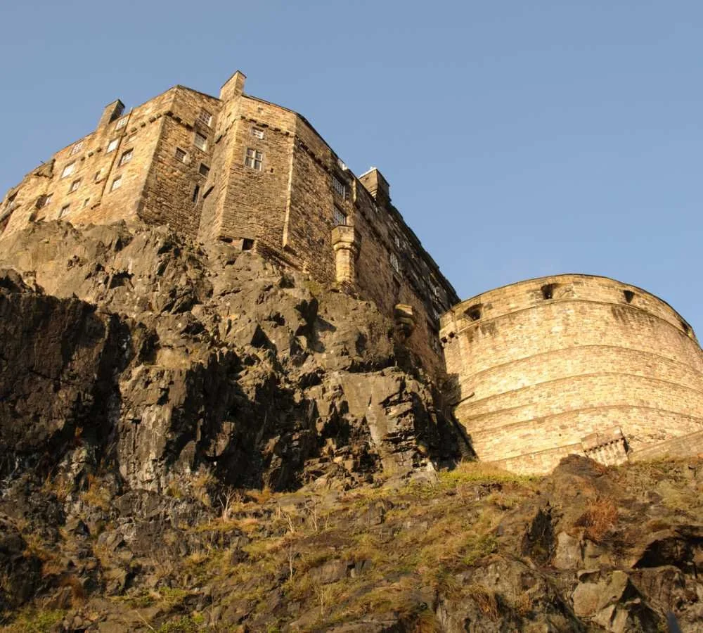 The curved Half Moon Battery and walls of Edinburgh Castle rising from the rock