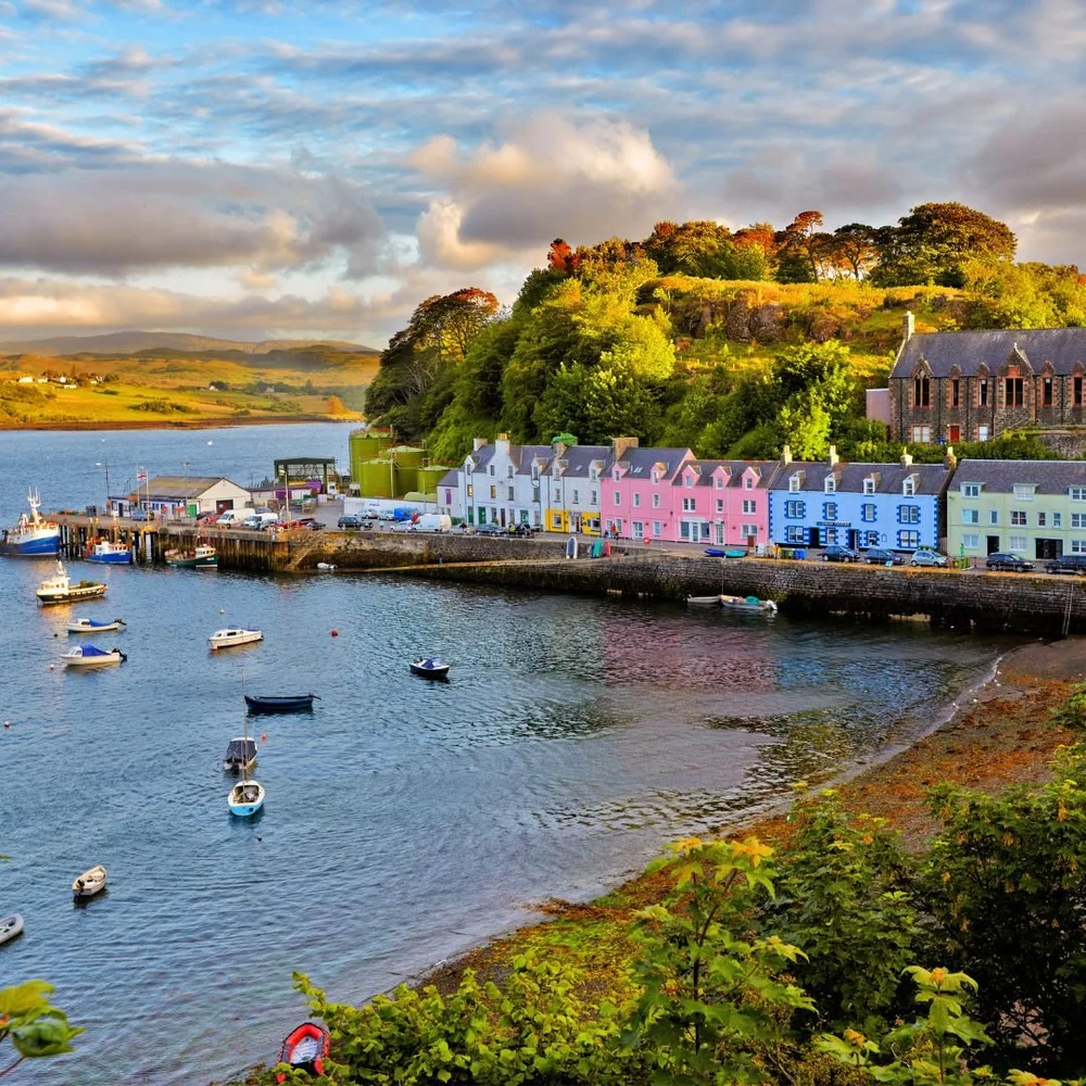 Colourful waterfront buildings and moored boats in Portree harbour, Isle of Skye