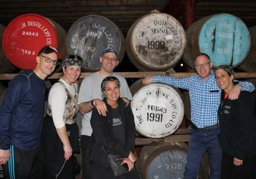 Scotland's Wild travellers beside whisky casks