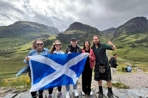 Scotland's Wild guide Pete with a small group holding a Saltire in Glencoe