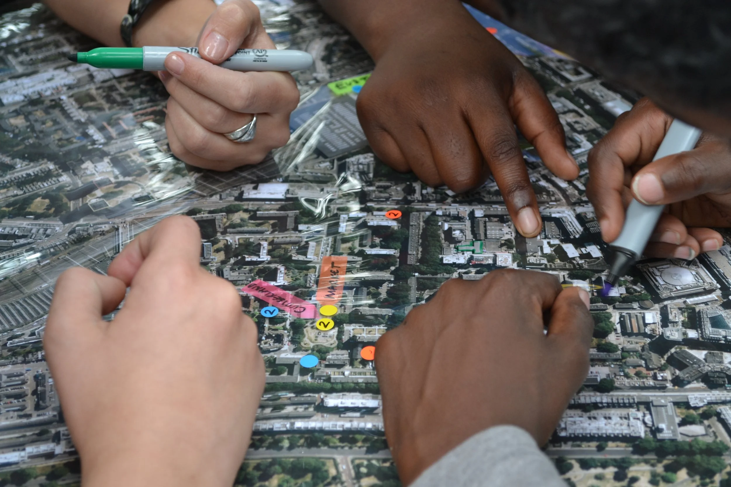 People drawing over an aerial view plan