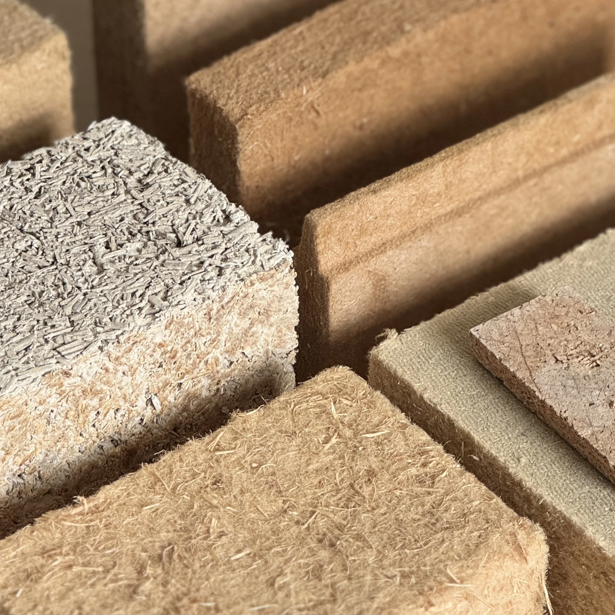 An image of natural material samples -Hempcrete,  wood fibre board, clay